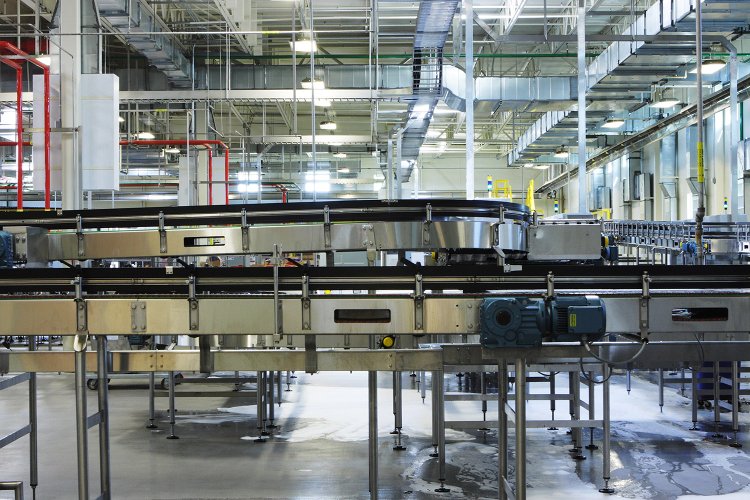 Factory conveyor machinery for transport and packaging of food and beverage products.